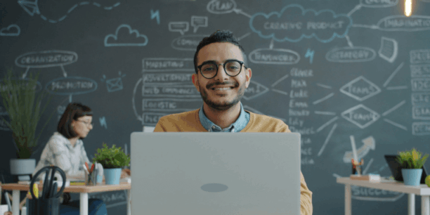 Man smiling behind a laptop
