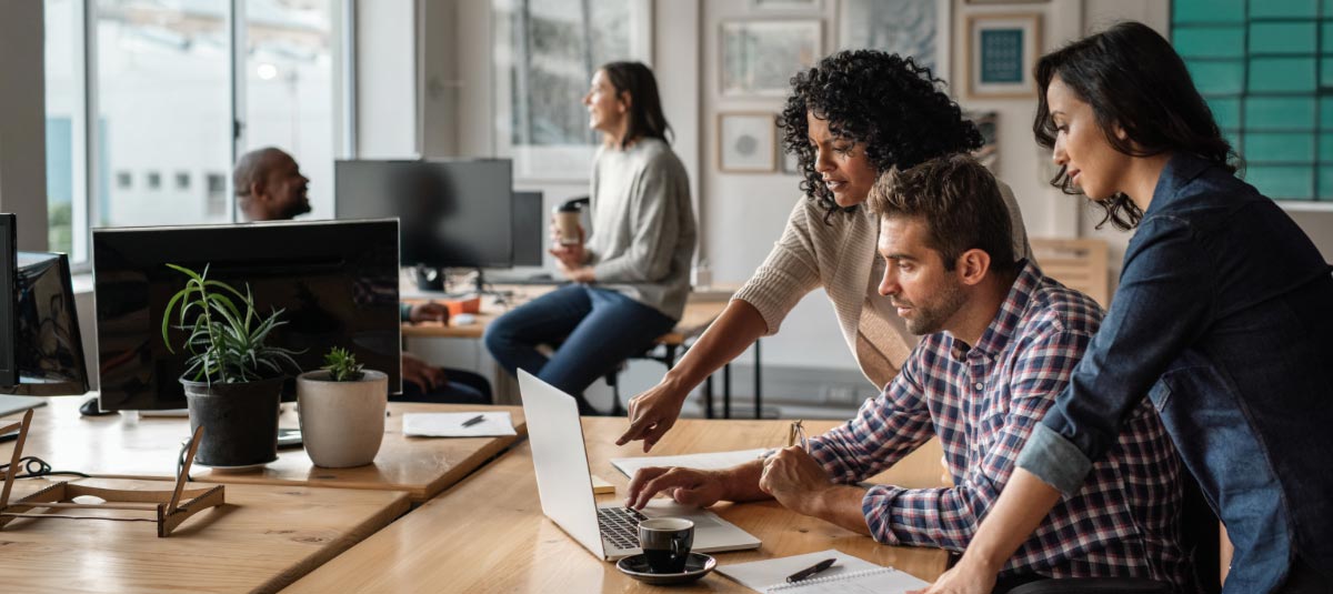 group of people hovering over laptop