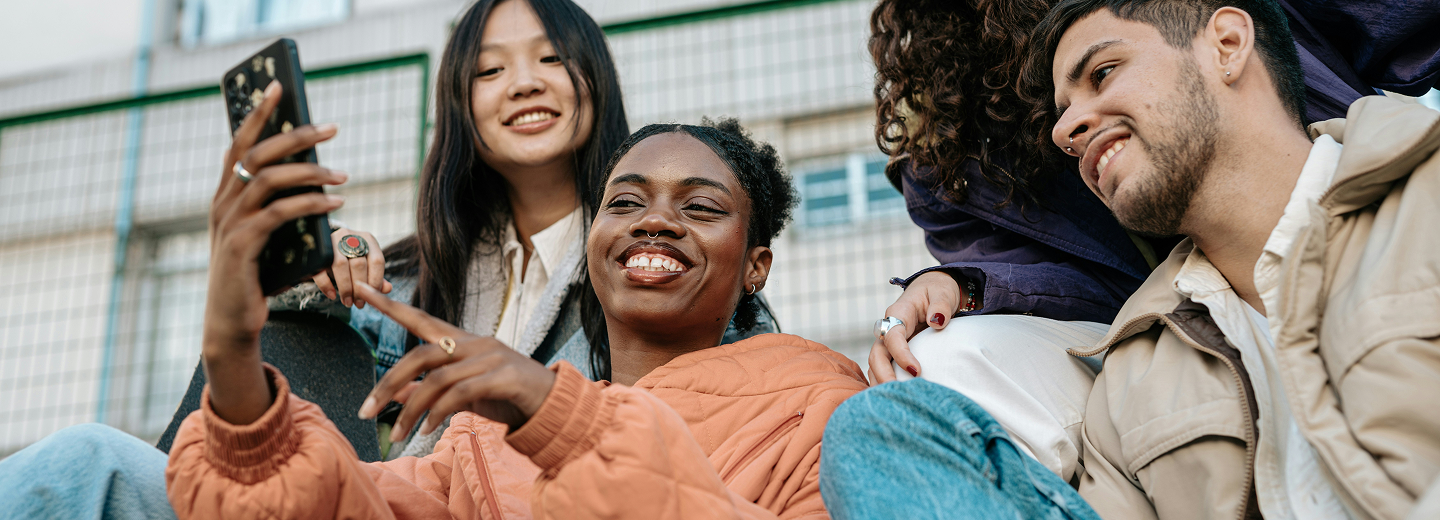 Young people laughing and looking at smartphone together