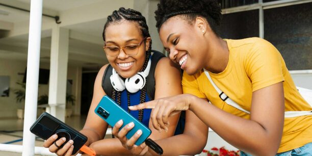 Two young women sharing something on their cellphones